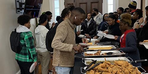 黑人校友会社区参与午餐会，会员在自助排队领取食物.