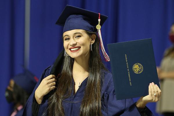 学生戴着学士帽，拿着毕业证书，面带微笑